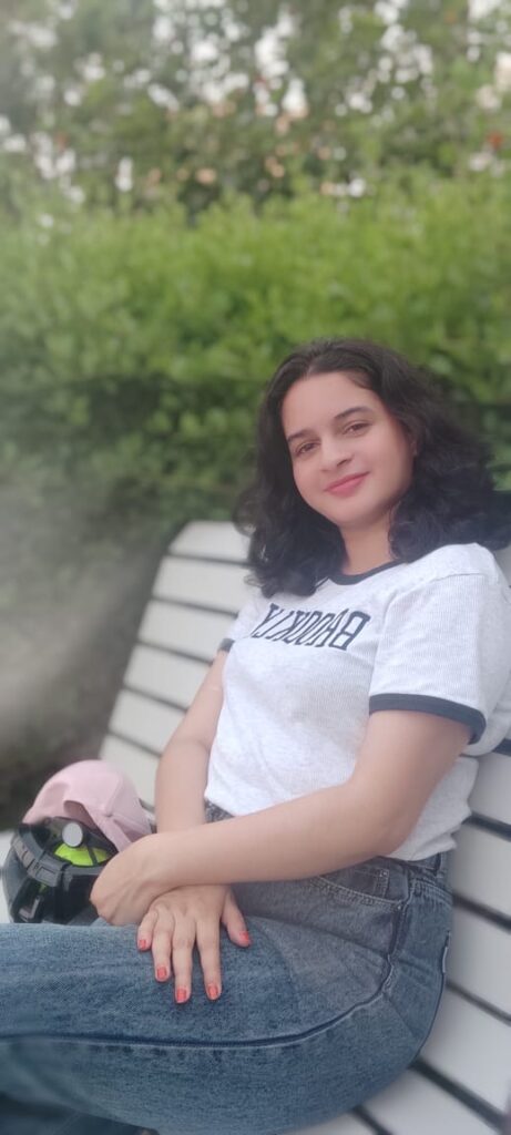 A beautiful lady was sitting at the table and smiling at me.